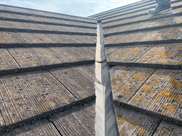 色褪せて苔が繁殖したセメント瓦屋根